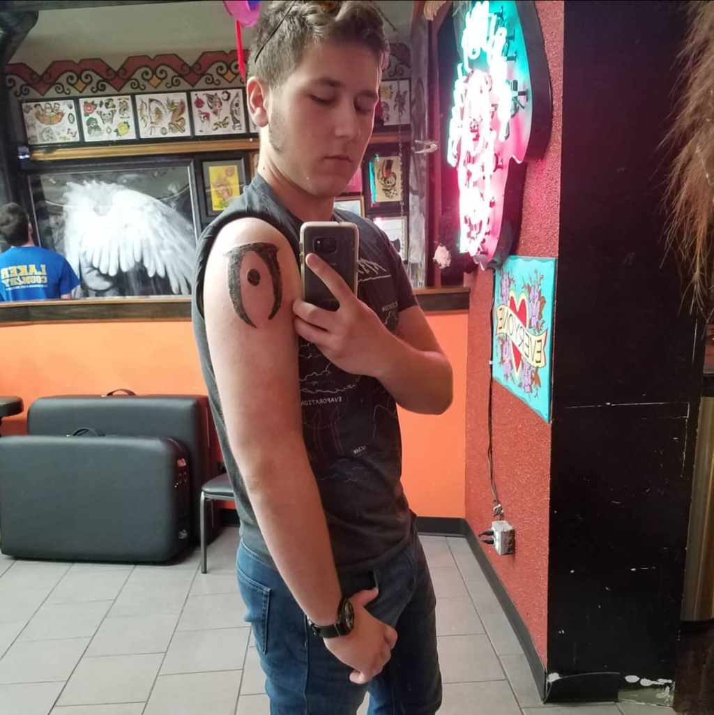 My son Kyle with his first tattoo on his upper arm: The Oblivion logo from The Elder Scrolls IV. He was that obsessed. 